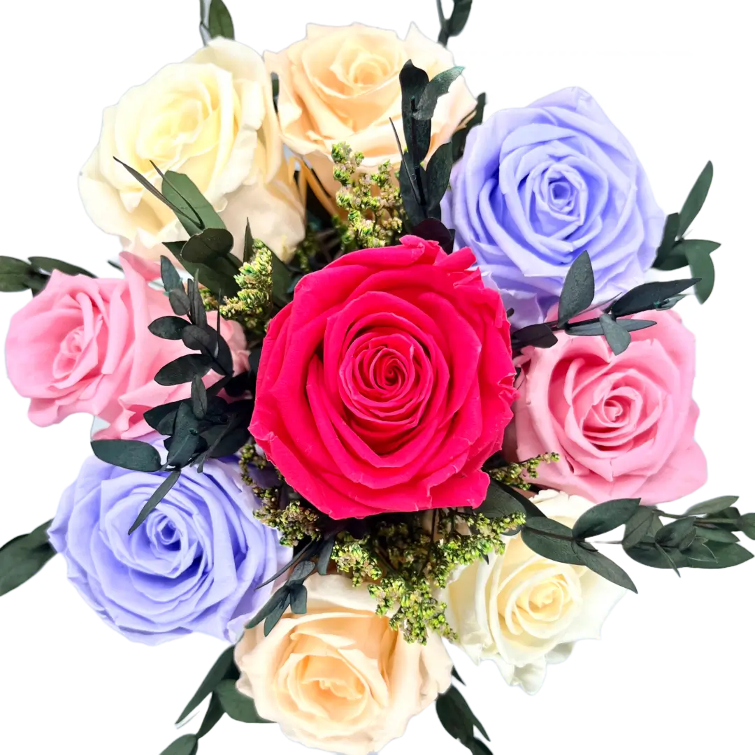 A bouquet of roses in different colors on a table.